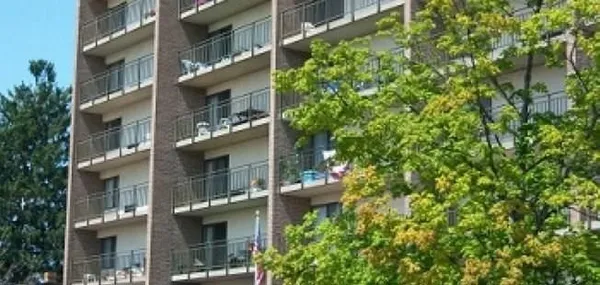 a front view of a multi story building with a yard