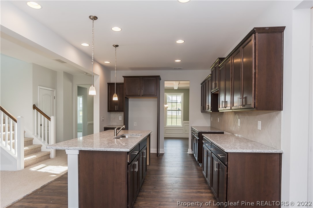 454 Pittfield Run Cameron, NC 28326 - Photo 14 of 37 a kitchen with stainless steel appliances granite countertop a refrigerator a sink dishwasher a stove and a dining table with wooden floor