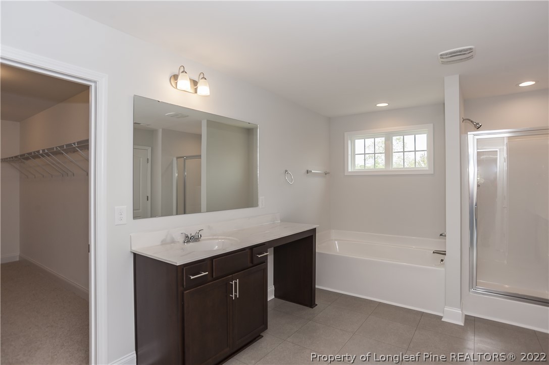 454 Pittfield Run Cameron, NC 28326 - Photo 36 of 37 a bathroom with a tub a sink shower and mirror