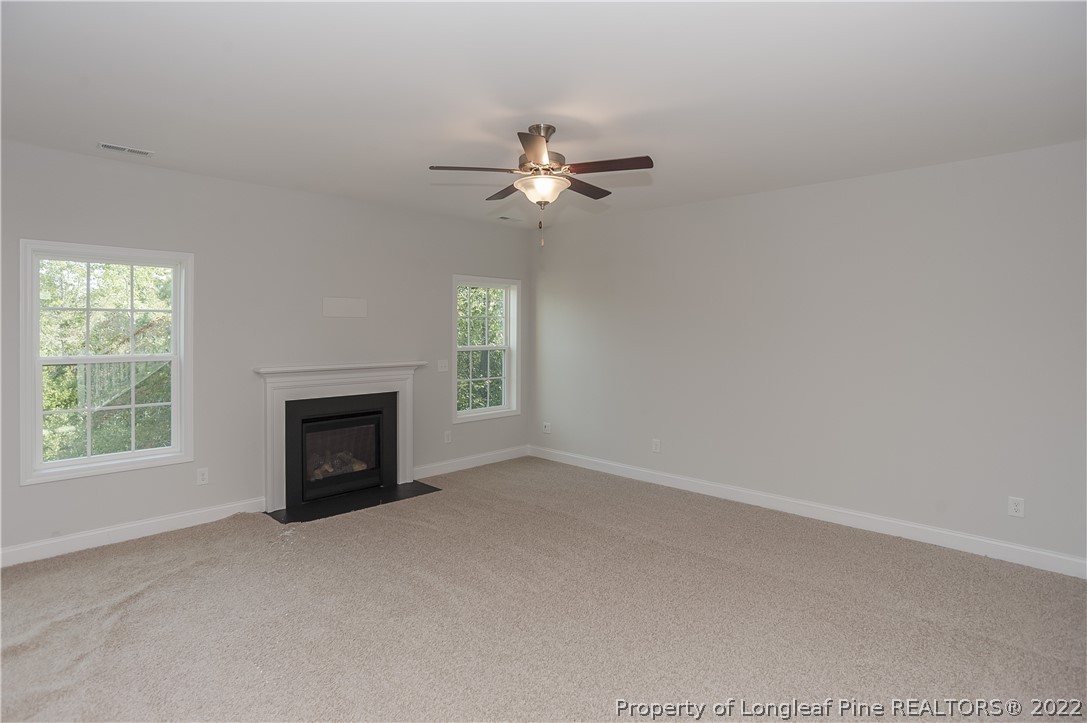 454 Pittfield Run Cameron, NC 28326 - Photo 9 of 37 an empty room with fireplace and fan