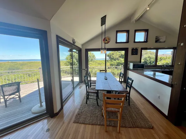 a dining room with wooden floor a glass table and chairs