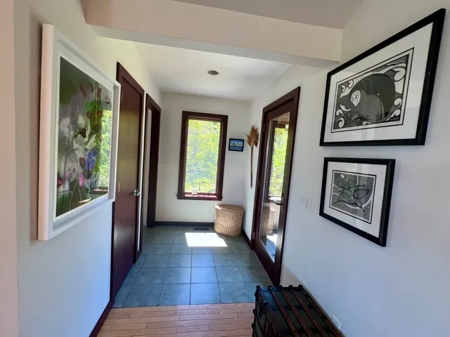 a view of a hallway with wooden floor and a window
