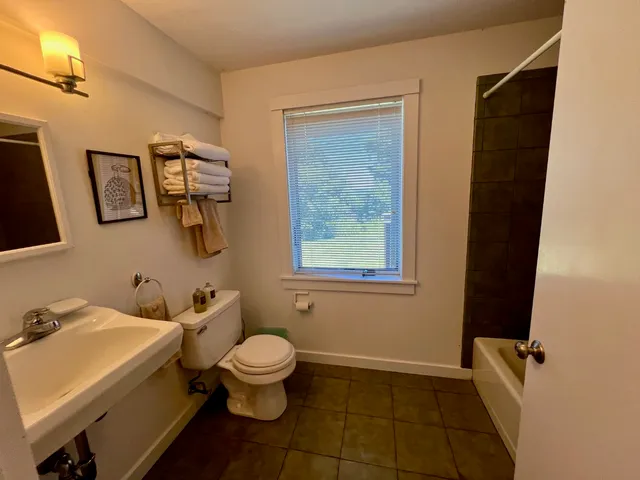 a bathroom with a granite countertop toilet a sink and a mirror