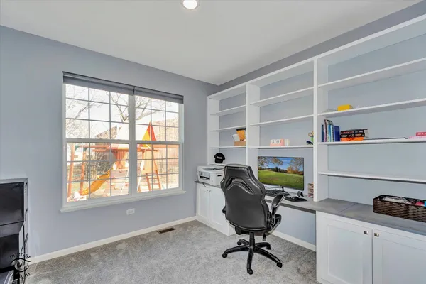 a view of a workspace with furniture and a window