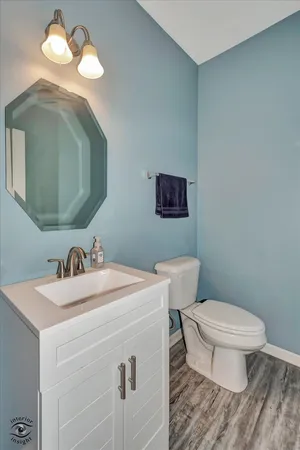 a bathroom with a toilet a sink and mirror