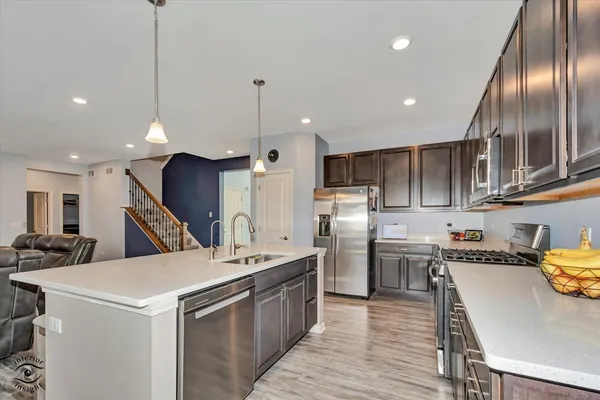 a kitchen that has a lot of cabinets a sink and appliances in it