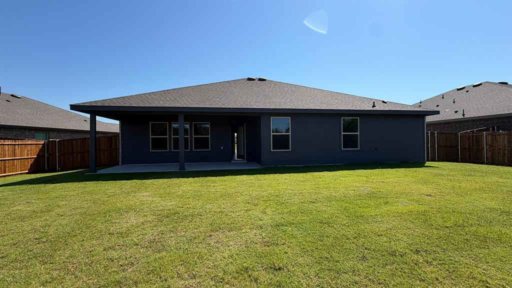 1913 Reveille Way Terrell, TX 75160 - Photo 2 of 35 Expansive backyard featuring a covered patio, concrete slab, wood privacy fencing, and a dark-colored exterior