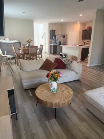 a living room with furniture and a wooden floor
