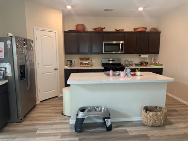 a kitchen with stainless steel appliances a microwave and cabinets