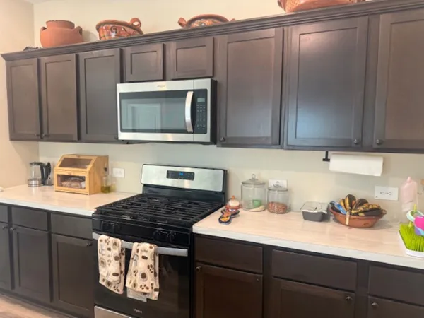 a kitchen with stainless steel appliances granite countertop a sink stove and cabinets