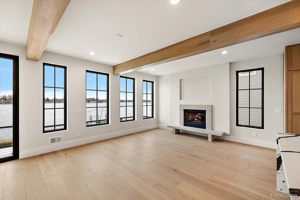 13459 Haddon Street Fenton, MI 48430 - Photo 13 of 84 Unfurnished living room with beam ceiling, light wood-style floors, a lit fireplace, and recessed lighting