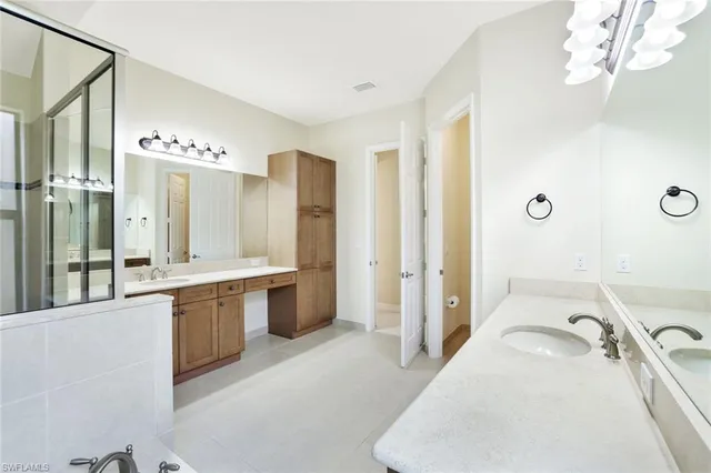 a spacious bathroom with a granite countertop sink mirror and a bathtub