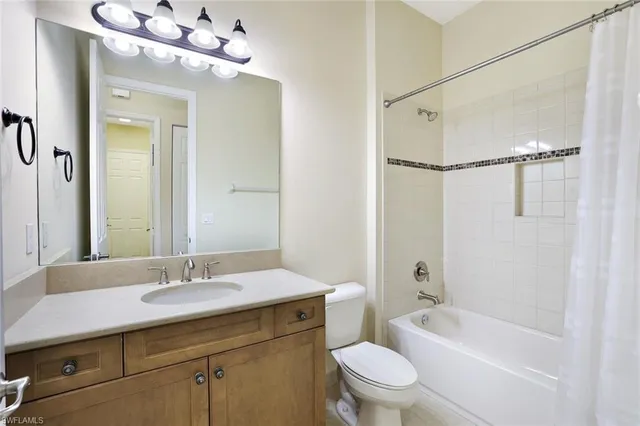 a bathroom with a sink a toilet a mirror and shower