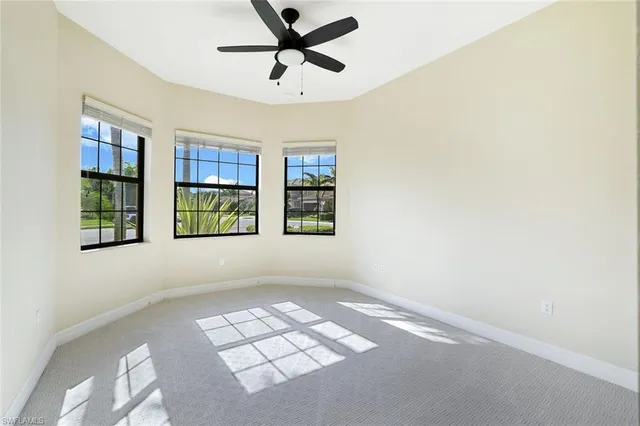 a view of an empty room with window and stairs