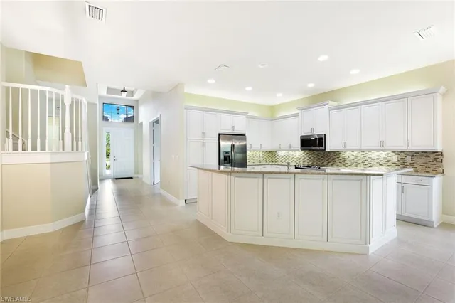 a kitchen with granite countertop white cabinets and stainless steel appliances