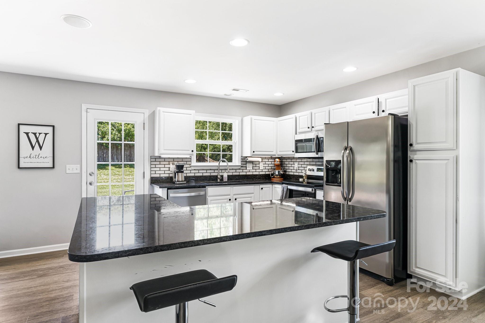 335 West Swift Creek Road Fletcher, NC 28732 - Photo 12 of 37 a kitchen with stainless steel appliances granite countertop a refrigerator a stove a sink dishwasher a stove and white cabinets with wooden floor