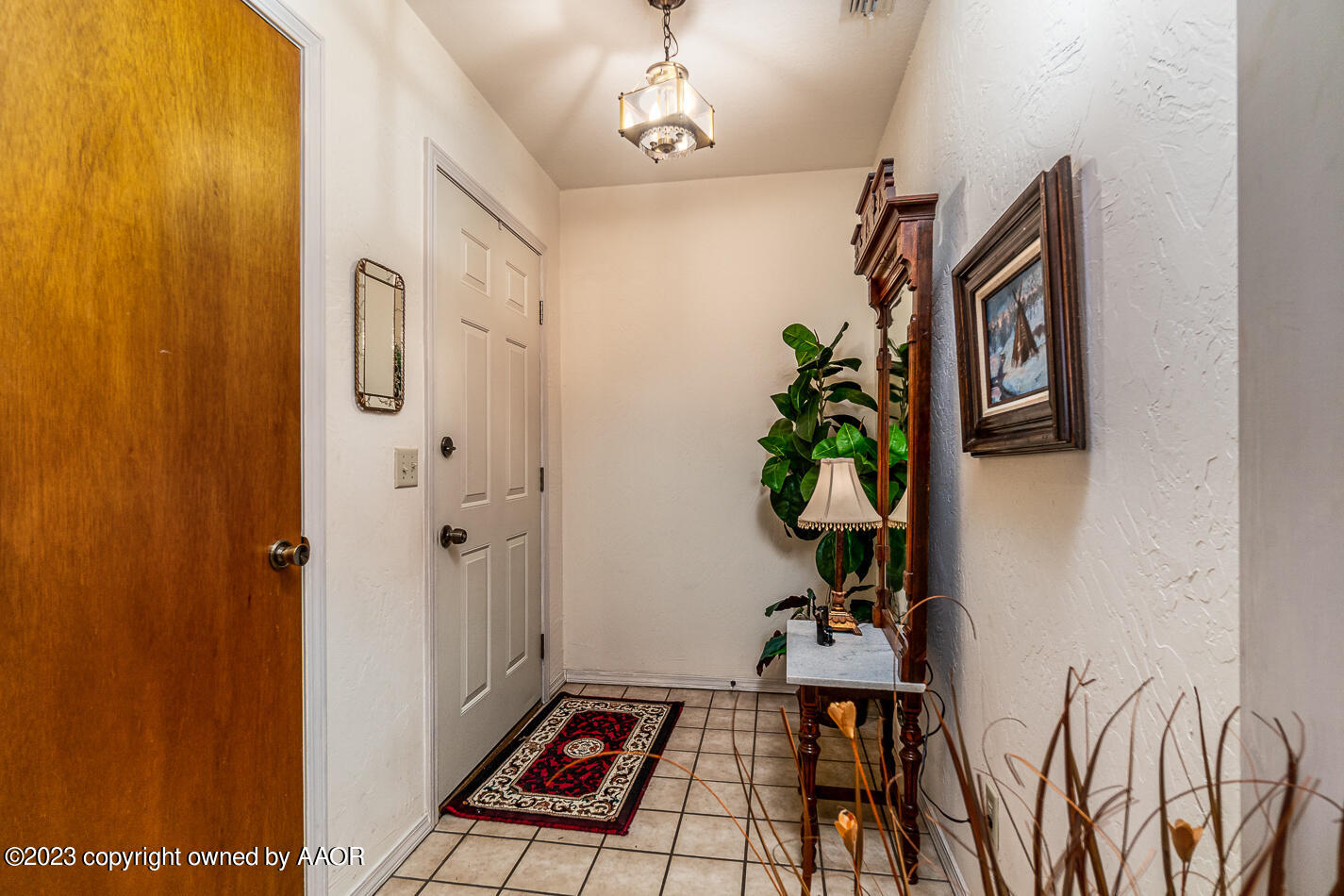 3406 Gladstone Lane Amarillo, TX 79121 - Photo 2 of 21 a view of a hallway with wooden floor and a potted plant
