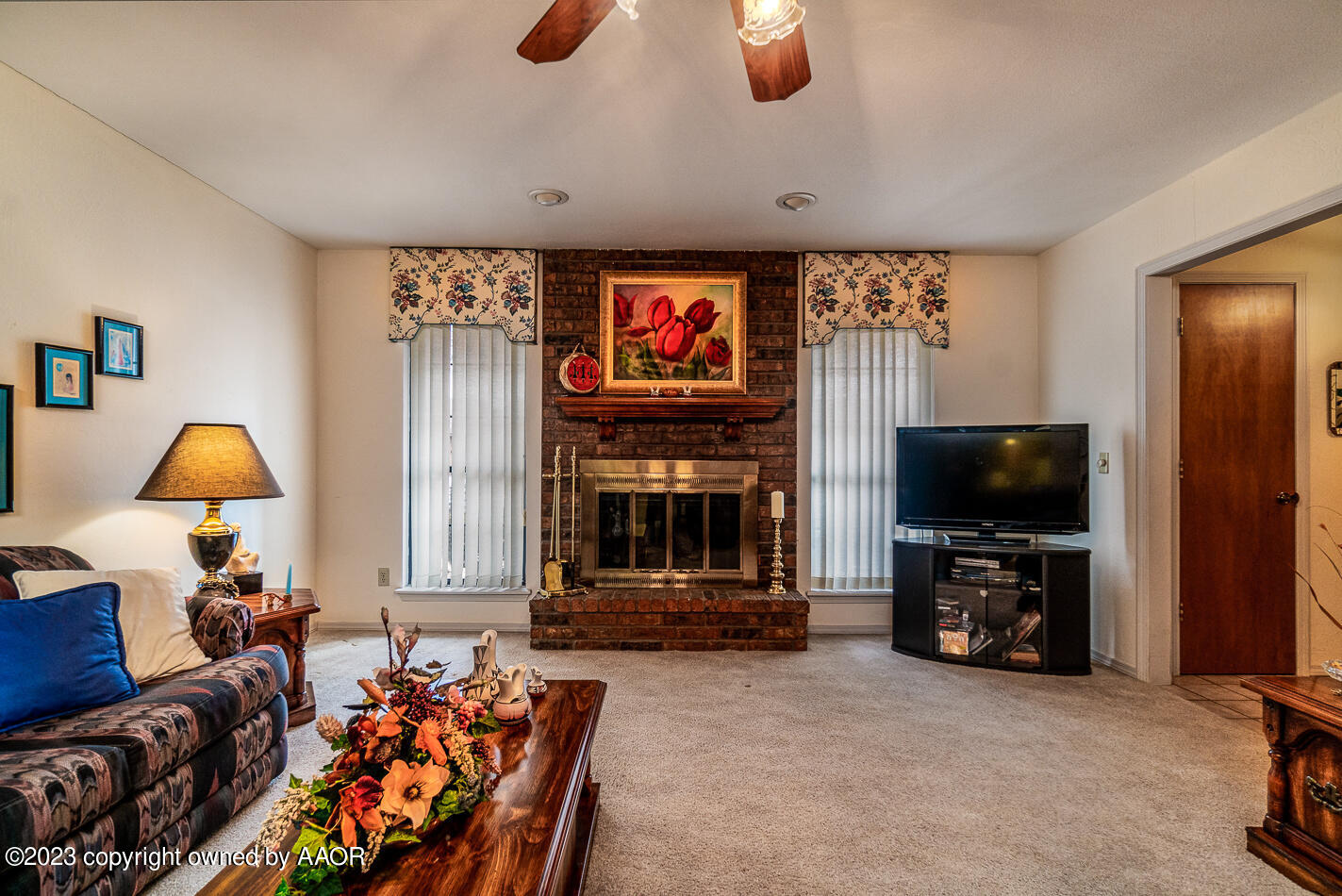 3406 Gladstone Lane Amarillo, TX 79121 - Photo 3 of 21 a living room with furniture a flat screen tv and a fireplace
