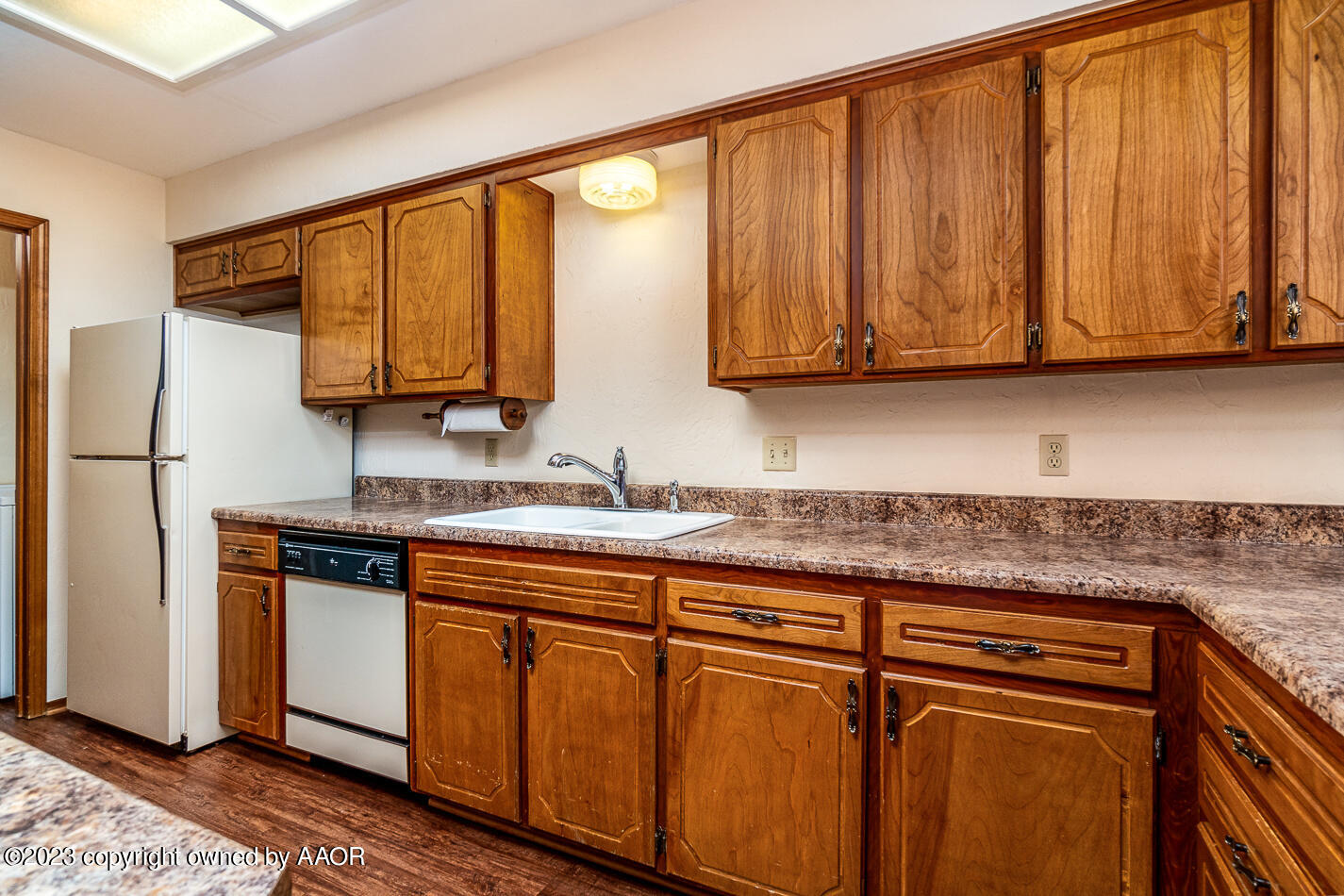 3406 Gladstone Lane Amarillo, TX 79121 - Photo 9 of 21 a kitchen with stainless steel appliances granite countertop wooden cabinets a sink and a dishwasher with wooden floor