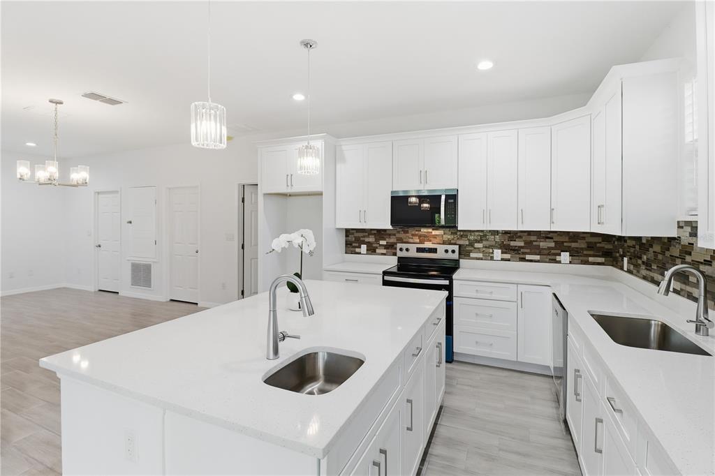 822 Poplar Street Inverness, FL 34452 - Photo 11 of 45 a kitchen with a sink a stove a microwave and cabinets