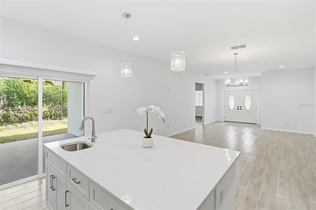 822 Poplar Street Inverness, FL 34452 - Photo 12 of 45 a kitchen with a sink a large window and wooden floor