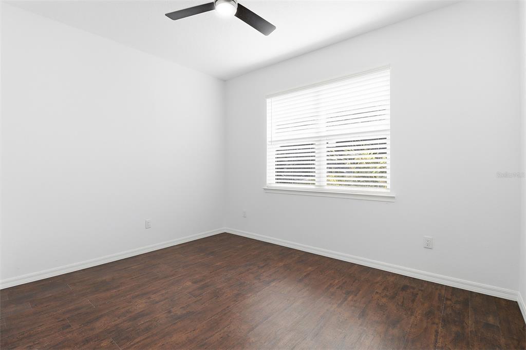 822 Poplar Street Inverness, FL 34452 - Photo 28 of 45 an empty room with wooden floor and windows