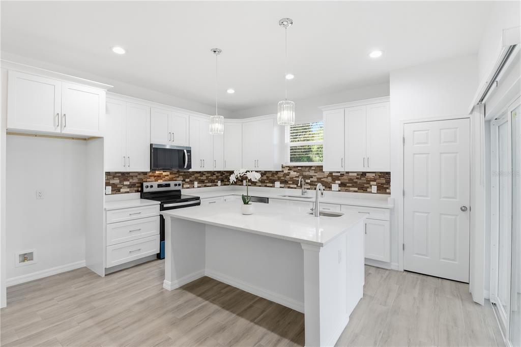 822 Poplar Street Inverness, FL 34452 - Photo 10 of 45 a kitchen with white cabinets and appliances