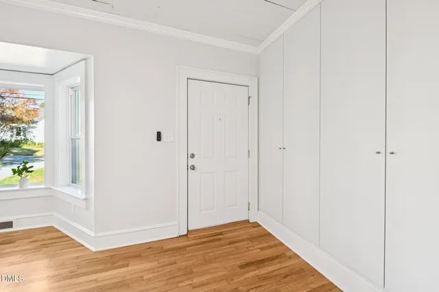 a view of an empty room with a fireplace and wooden floor