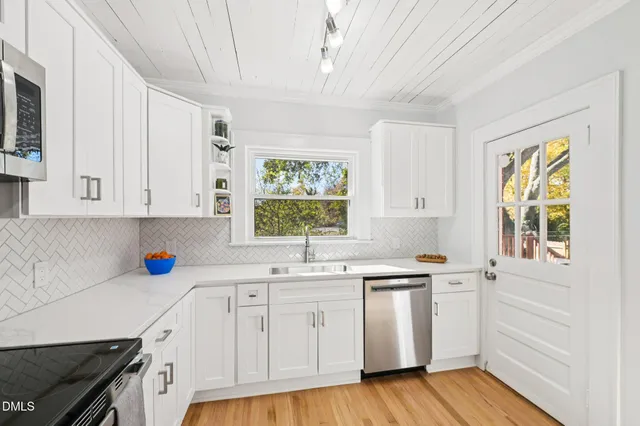 a kitchen with stainless steel appliances granite countertop a refrigerator stove and sink