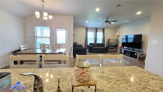 a living room with furniture a chandelier and a flat screen tv