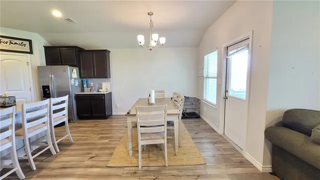 a view of a dining room with furniture a chandelier and wooden floor