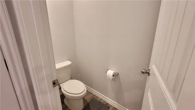 a white toilet sitting next to a shower