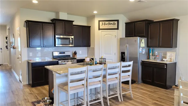 a kitchen with a refrigerator and a stove top oven