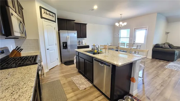 a kitchen with stainless steel appliances granite countertop a sink stove and refrigerator