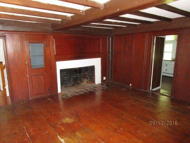 46 Main Street Brewster, MA 02631 - Photo 13 of 19 a view of empty room with wooden floor and fireplace