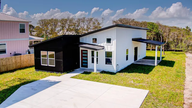 a view of a white house with a large pool of the house