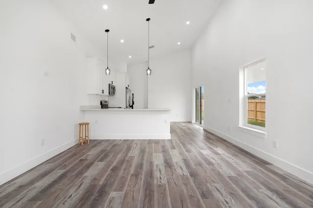 a kitchen with stainless steel appliances kitchen island a refrigerator sink and white cabinets