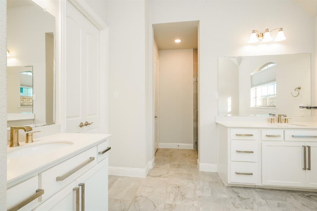 2000 Johnson Road Mansfield, TX 76063 - Photo 15 of 27 Dual vanity with white cabinetry, gold-finish fixtures, and a large wall-mounted mirror