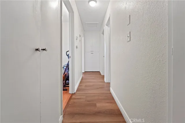a view of a hallway with wooden floor and staircase