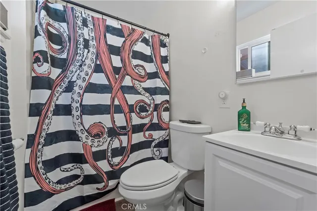 a bathroom with a toilet and a shower curtain