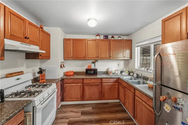 a kitchen with stainless steel appliances granite countertop a stove a sink dishwasher and a refrigerator