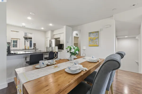 a kitchen with kitchen island stainless steel appliances granite countertop a dining table and chairs