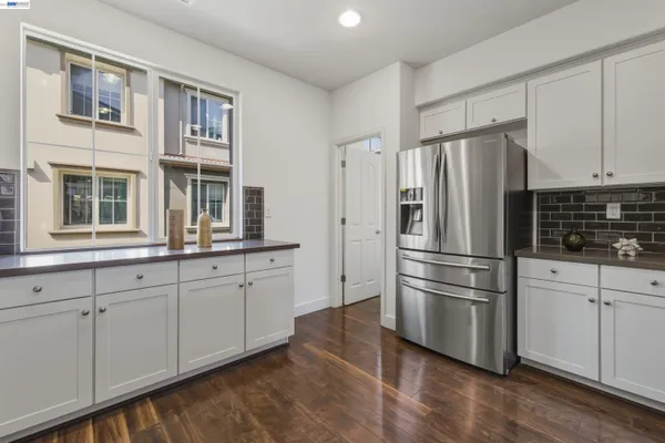 a kitchen with granite countertop white cabinets and stainless steel appliances