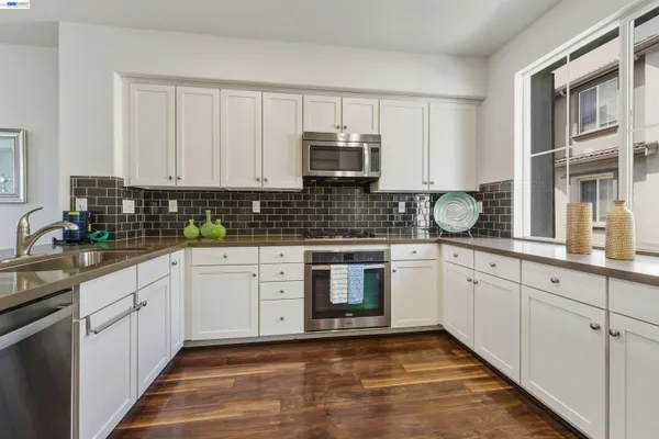 a kitchen with stainless steel appliances granite countertop a stove sink and cabinets