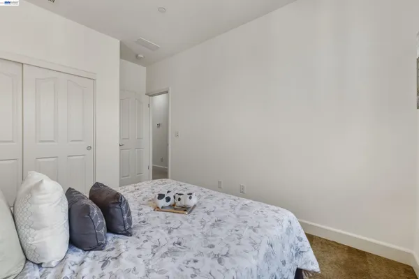 a bedroom with a bed and a lamp on dresser