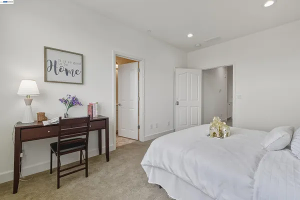 a bedroom with a bed and a lamp on dresser