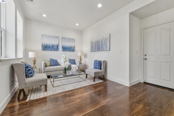 a living room with furniture and a wooden floor