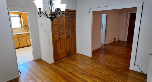 a view of a hallway with wooden floor and stairs