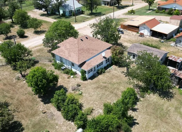 an aerial view of a house with a yard and a large tree