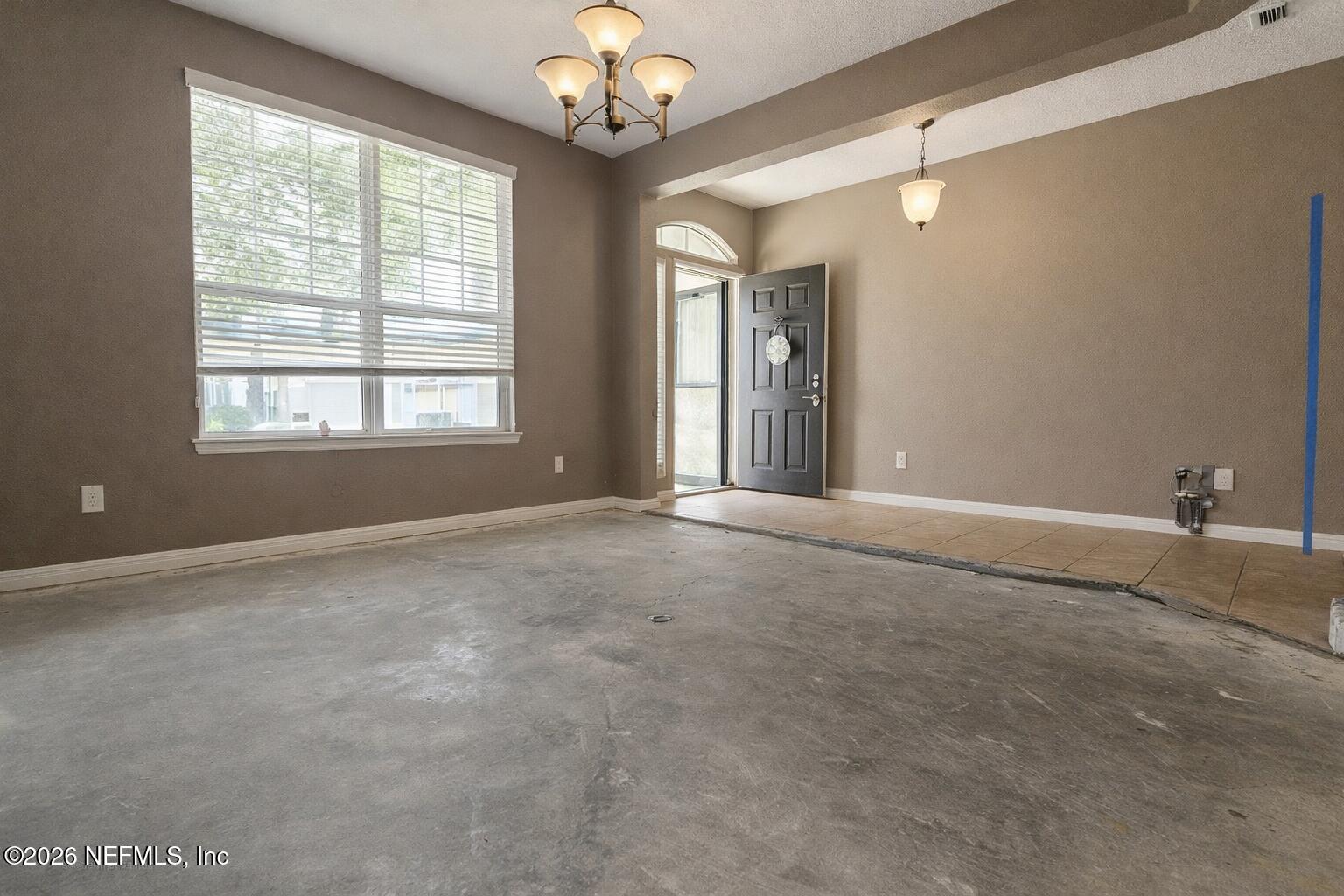 217 Amber Ridge Road Jacksonville, FL 32218 - Photo 16 of 42 an empty room with chandelier fan and windows